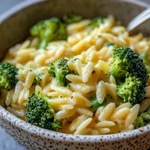 Creamy one-pot broccoli cheddar pasta served in a bowl with fresh broccoli.
