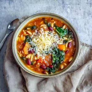 Bowl of creamy pumpkin minestrone with fresh herbs and vegetables