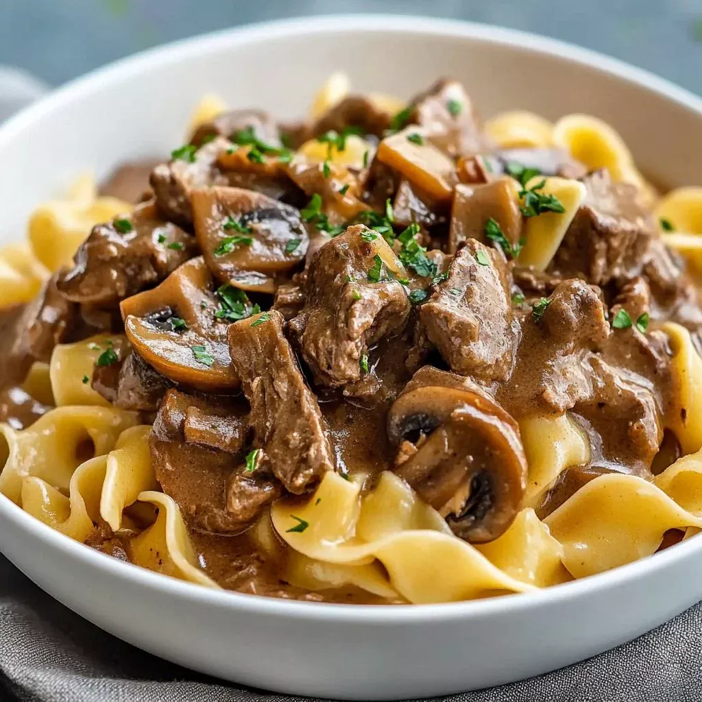 Bowl of slow cooker hearty beef stroganoff with noodles and mushrooms